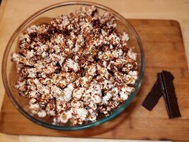 miska popcornu czekoladowego z tabliczką czekolady w tle